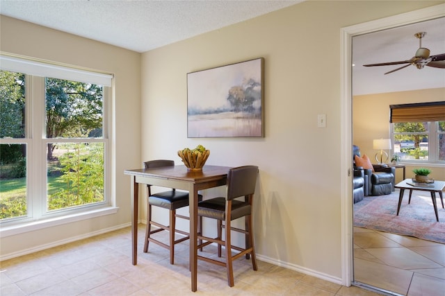 dining area featuring a textured ceiling, ceiling fan, and a healthy amount of sunlight