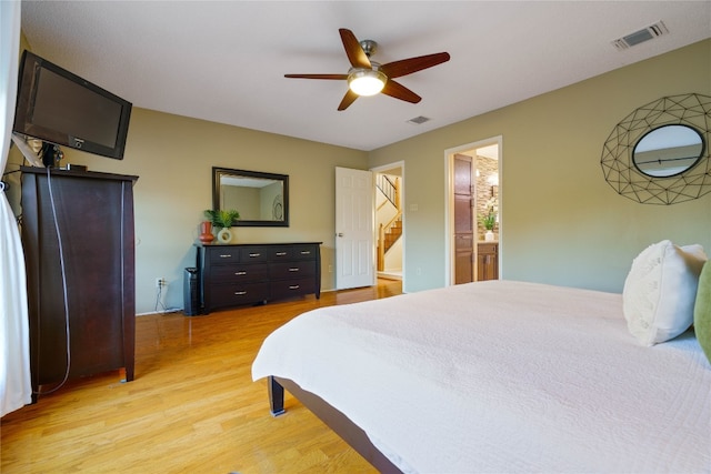 bedroom featuring light hardwood / wood-style floors, ensuite bath, and ceiling fan