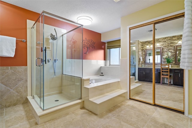 bathroom featuring tile patterned flooring, vanity, shower with separate bathtub, and a textured ceiling