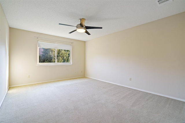 carpeted empty room with ceiling fan and a textured ceiling