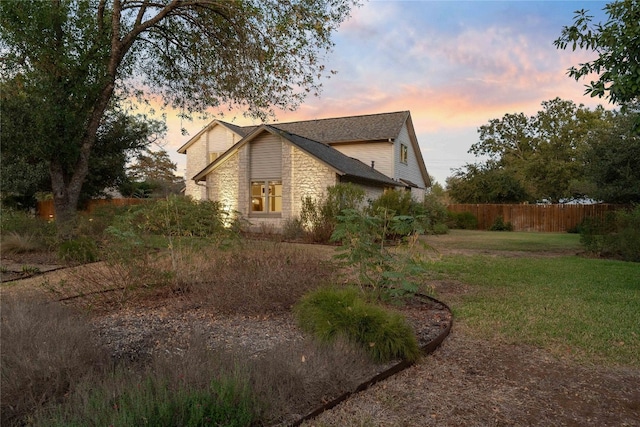 property exterior at dusk with a yard