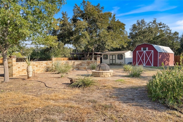 view of yard featuring an outdoor fire pit and an outdoor structure