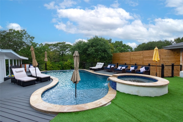 view of swimming pool with a yard, an in ground hot tub, pool water feature, and a wooden deck