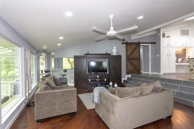 living room featuring lofted ceiling, ceiling fan, a barn door, and dark hardwood / wood-style floors