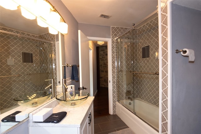 bathroom featuring tile patterned flooring, shower / bath combination with glass door, and vanity