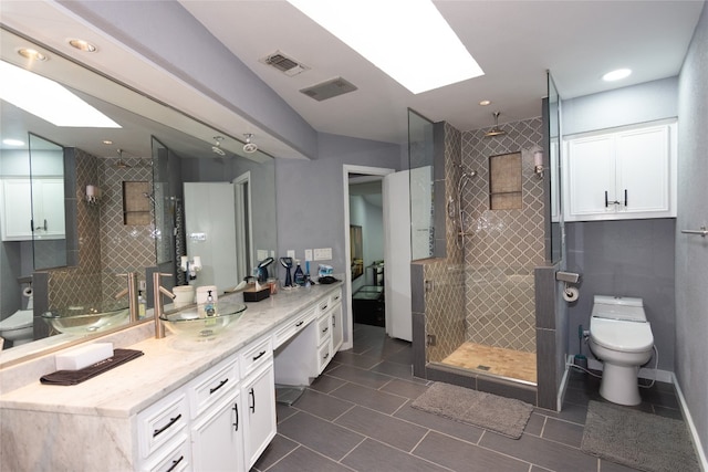 bathroom featuring an enclosed shower, a skylight, vanity, and toilet