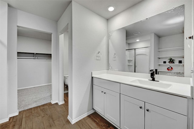 bathroom with hardwood / wood-style floors, vanity, and toilet