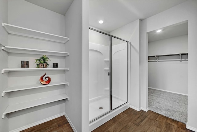 bathroom with a shower with shower door and hardwood / wood-style flooring