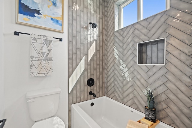 bathroom with tiled shower / bath combo and toilet