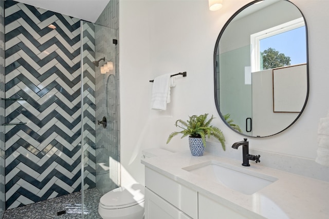 bathroom featuring vanity, toilet, and a shower with shower door