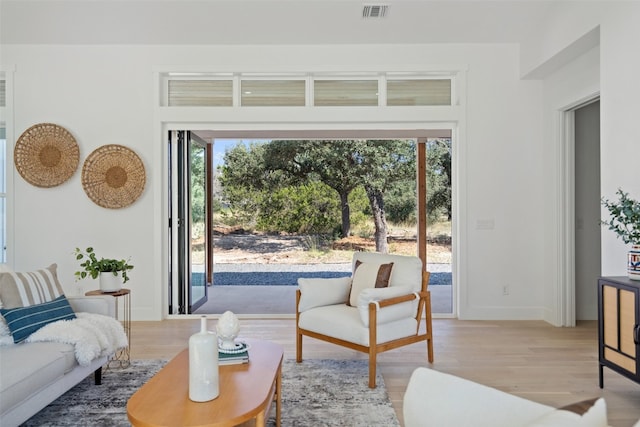 living room featuring a healthy amount of sunlight and light hardwood / wood-style flooring