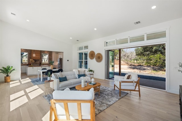 living room featuring light hardwood / wood-style floors and high vaulted ceiling