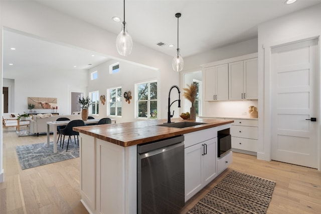 kitchen featuring wood counters, white cabinetry, dishwasher, and sink