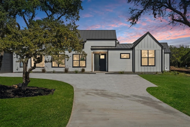 modern farmhouse with a lawn and a garage