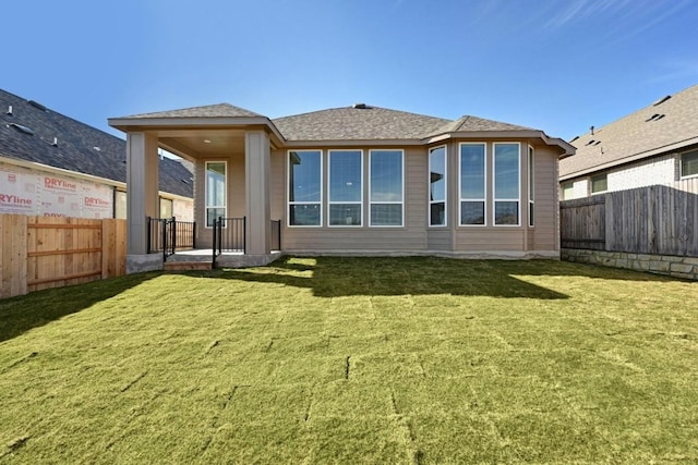 rear view of property featuring a yard