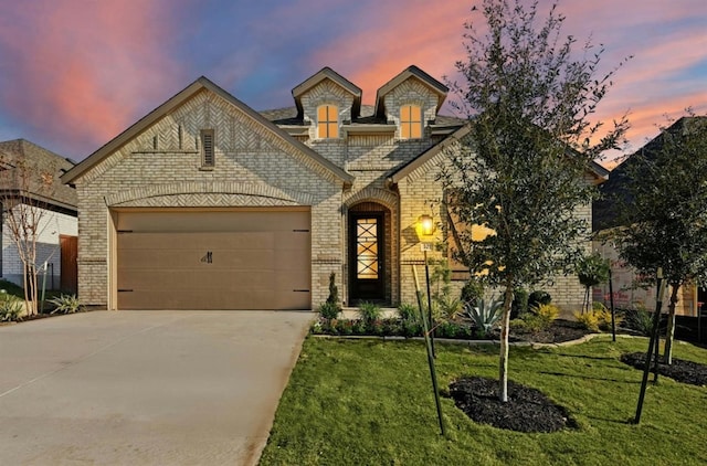 french country style house featuring a yard and a garage