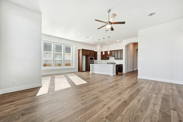 unfurnished living room featuring light hardwood / wood-style flooring and ceiling fan