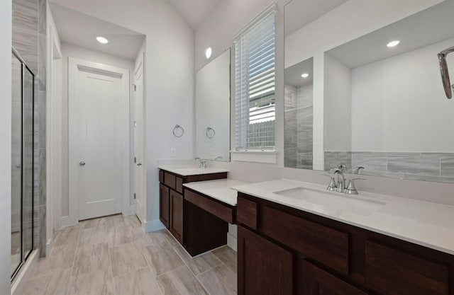 bathroom with vanity and a shower with door