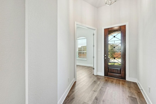 foyer entrance with hardwood / wood-style floors and a chandelier