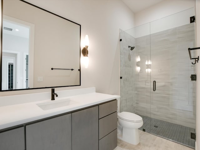 bathroom with vanity, toilet, a shower with shower door, and tile patterned flooring