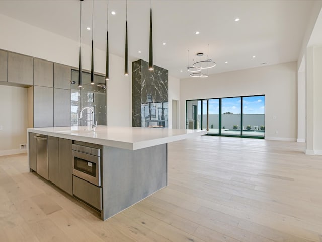 kitchen featuring light hardwood / wood-style floors, sink, and hanging light fixtures