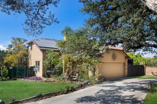 view of front of home with a garage, solar panels, and a front yard