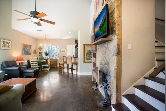 living room featuring a fireplace, a towering ceiling, and ceiling fan with notable chandelier