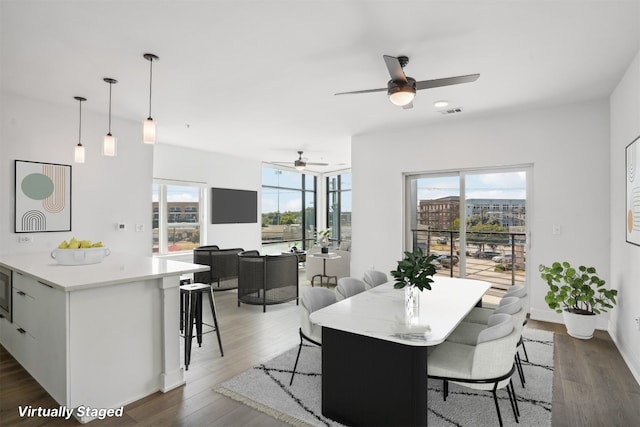 dining room with a wealth of natural light, dark wood-type flooring, and ceiling fan