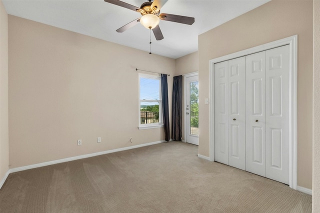 unfurnished bedroom with access to exterior, light colored carpet, a closet, and ceiling fan