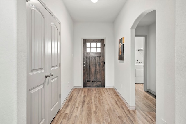 foyer with light wood-type flooring and washer / dryer