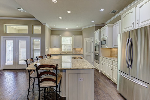 kitchen featuring a center island, dark hardwood / wood-style flooring, light stone countertops, and appliances with stainless steel finishes