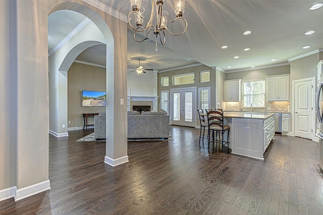 kitchen featuring white cabinetry, a center island, dark wood-type flooring, a kitchen bar, and decorative backsplash