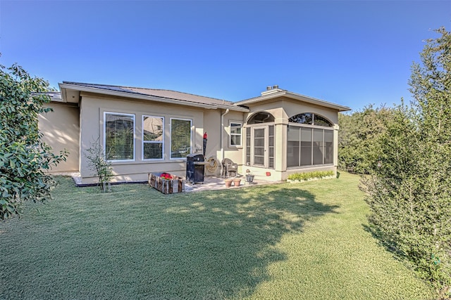 rear view of property featuring a lawn and a sunroom