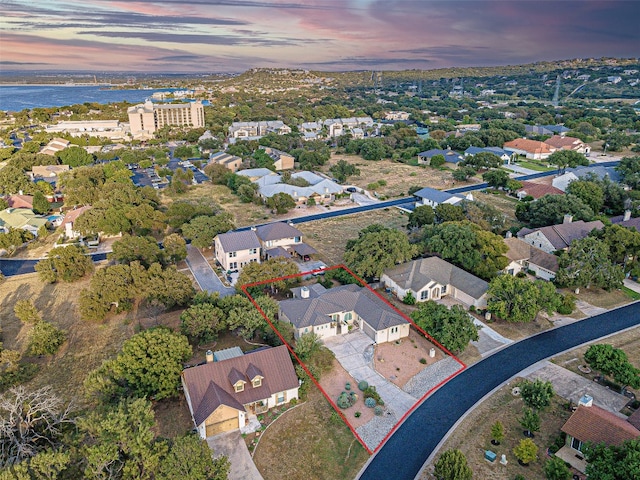 aerial view at dusk featuring a water view