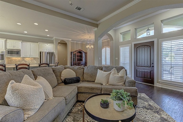 living room featuring dark hardwood / wood-style flooring, a chandelier, and ornamental molding