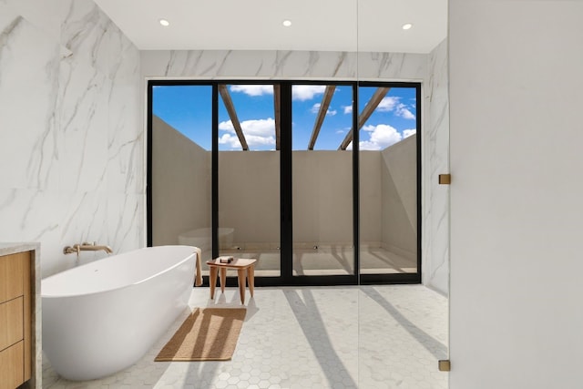 bathroom with tile walls, vanity, and independent shower and bath