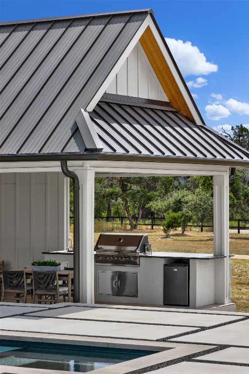 view of patio featuring a pool, area for grilling, and exterior kitchen