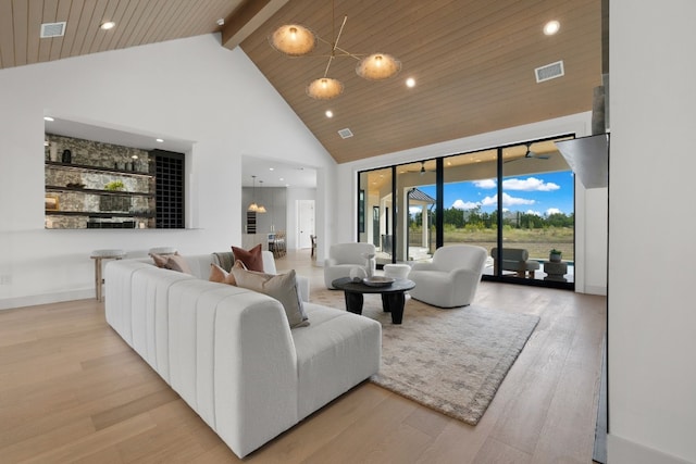 living room with light wood-type flooring, high vaulted ceiling, beam ceiling, and wooden ceiling