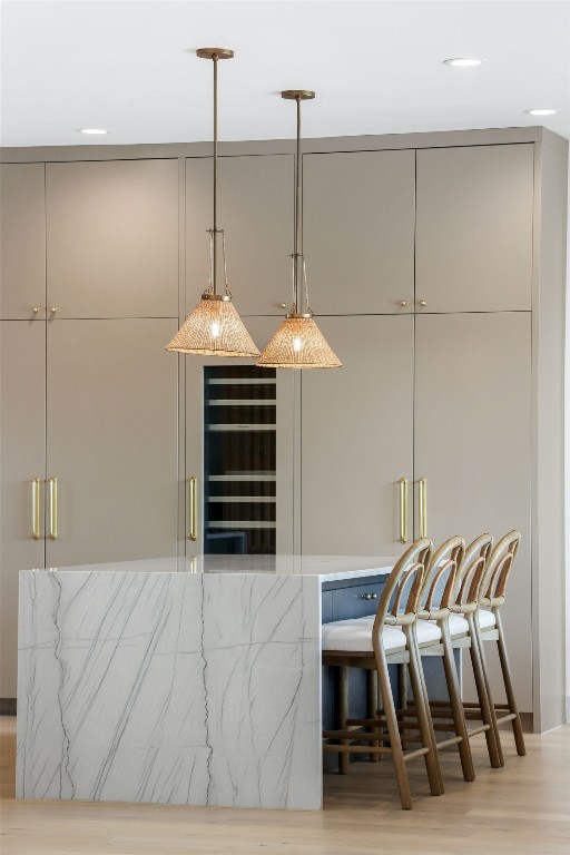 bar featuring light hardwood / wood-style floors and decorative light fixtures