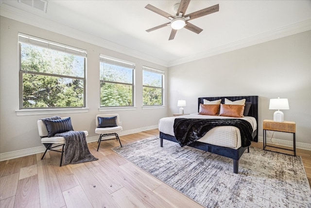 bedroom featuring crown molding, light wood-type flooring, and ceiling fan