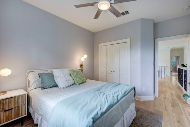 bedroom with a closet, light wood-type flooring, and ceiling fan