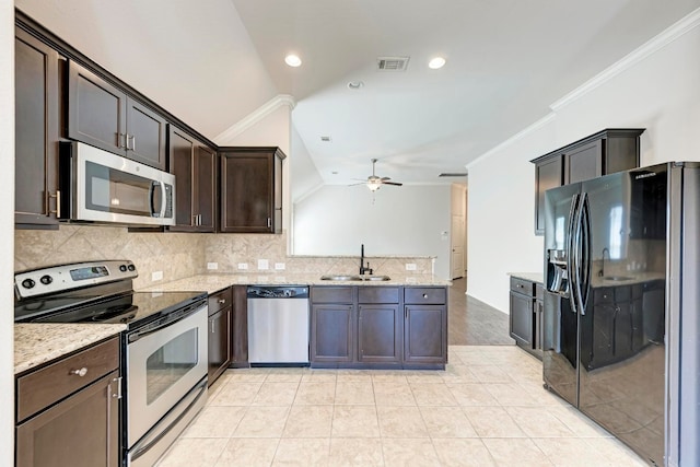 kitchen with lofted ceiling, crown molding, appliances with stainless steel finishes, and sink