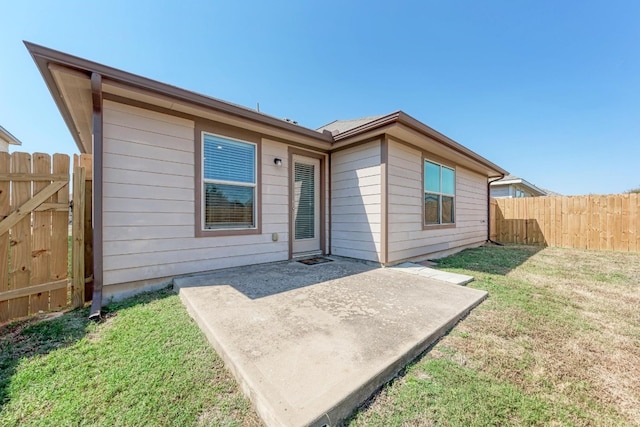 rear view of property featuring a patio and a lawn