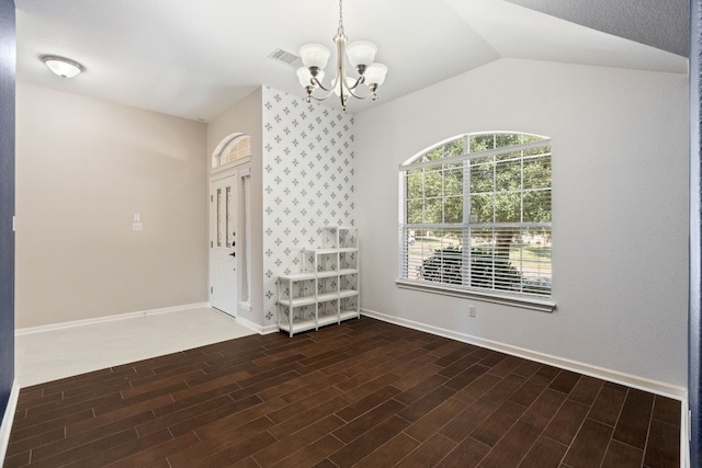 spare room with vaulted ceiling and a notable chandelier