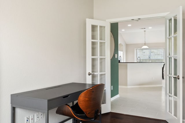 tiled office featuring french doors, lofted ceiling, and sink