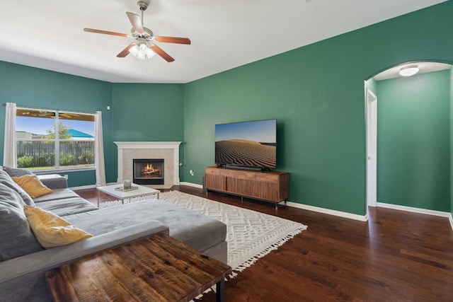 living room with ceiling fan and dark wood-type flooring