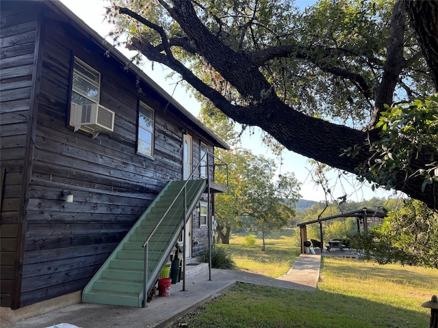 view of side of property with cooling unit and a lawn