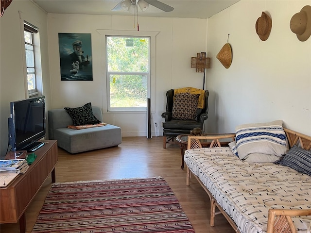 sitting room with wood-type flooring, ceiling fan, and a healthy amount of sunlight