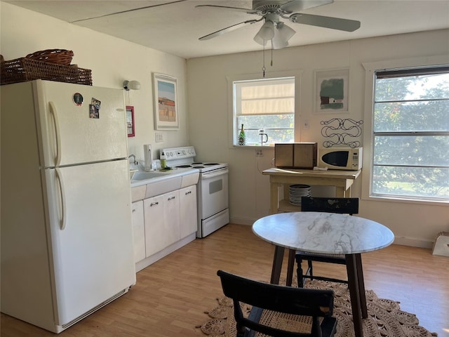 kitchen featuring white cabinets, light wood-type flooring, white appliances, and a wealth of natural light