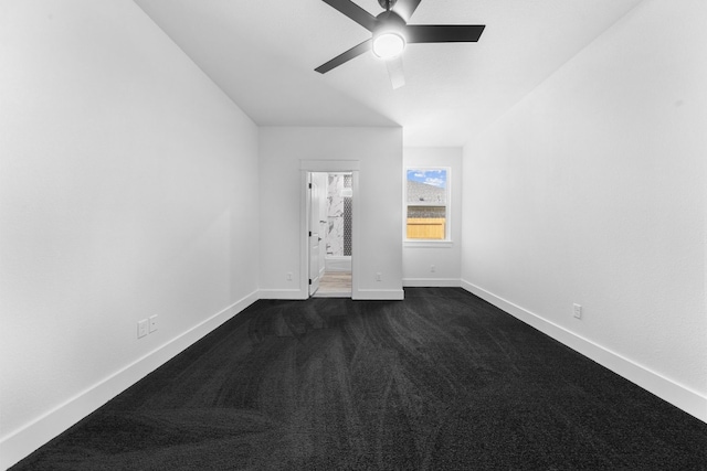 spare room featuring dark carpet and ceiling fan